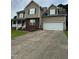 Beautiful tan two-story home with a spacious driveway, 2 car garage, and brick facade at 642 Pinevalley Ln, Sanford, NC 27332