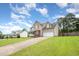 View of a charming two-story home with an attached garage and landscaped front yard at 642 Pinevalley Ln, Sanford, NC 27332