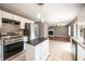 Kitchen leading into living room with stainless appliances, white cabinets, and tile floor at 642 Pinevalley Ln, Sanford, NC 27332