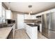 Well-lit kitchen featuring a stainless steel refrigerator, white cabinets, and island with dark countertop at 642 Pinevalley Ln, Sanford, NC 27332