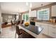Bright kitchen features white cabinets, a black countertop island, and a view to the living and dining area at 642 Pinevalley Ln, Sanford, NC 27332