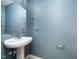 A modern half-bathroom features blue walls and a pedestal sink at 642 Pinevalley Ln, Sanford, NC 27332