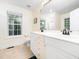 Well-lit bathroom featuring double sinks, tile flooring, and a large window at 65 Shorrey Pl, Youngsville, NC 27596