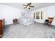 This bedroom is painted light blue with a ceiling fan and a large window letting in natural light at 65 Shorrey Pl, Youngsville, NC 27596