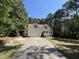 Beautiful home with an attached garage and a long driveway nestled amongst mature trees at 65 Shorrey Pl, Youngsville, NC 27596