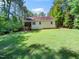 Spacious backyard with a view of the home's exterior, featuring a screened porch and well-maintained lawn at 65 Shorrey Pl, Youngsville, NC 27596