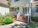 Charming front porch with brick steps and an inviting blue door with a decorative wreath at 65 Shorrey Pl, Youngsville, NC 27596