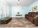 Spacious living area with a desk, brown leather couch, and hardwood flooring at 65 Shorrey Pl, Youngsville, NC 27596
