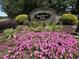 Beautifully landscaped entrance to Spencer's Gate community with stone signage and colorful flowers at 65 Shorrey Pl, Youngsville, NC 27596