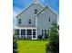 Rear exterior featuring a well-manicured lawn and screened in porch at 7117 Crested Iris Pl, Durham, NC 27703