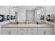 Bright bathroom features a long double vanity with stylish fixtures and a large mirror at 7117 Crested Iris Pl, Durham, NC 27703
