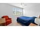 Cozy bedroom with a blue comforter, natural light, and a comfortable reading chair at 7117 Crested Iris Pl, Durham, NC 27703