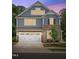 Charming two-story home featuring blue siding, stone accents, and a convenient two-car garage at 7117 Crested Iris Pl, Durham, NC 27703