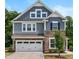 Beautiful two-story home featuring stone accents, a two-car garage, and professionally landscaped front yard at 7117 Crested Iris Pl, Durham, NC 27703