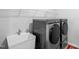 Efficient laundry room with modern washer and dryer, and a utility sink at 7117 Crested Iris Pl, Durham, NC 27703