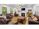 Comfortable living room features a fireplace, large windows, and plush leather furniture at 7117 Crested Iris Pl, Durham, NC 27703