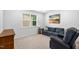 Cozy living room with carpet, a blue sofa, and a large window providing natural light at 7117 Crested Iris Pl, Durham, NC 27703