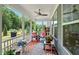 Outdoor porch is furnished with vibrant seating arrangements, potted plants, and a ceiling fan at 7117 Crested Iris Pl, Durham, NC 27703