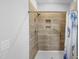 Modern shower featuring tiled walls, built-in shelving, and accessible handrails at 7117 Crested Iris Pl, Durham, NC 27703