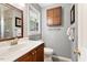 A bathroom with a white sink, dark wood cabinets, and a window for natural light at 7209 St Ledger Dr, Raleigh, NC 27613