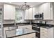 Modern kitchen with white cabinets, granite countertops, and stainless steel appliances at 7209 St Ledger Dr, Raleigh, NC 27613