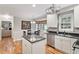 Well-lit kitchen with island, white cabinetry, stainless steel appliances, and a breakfast nook at 7209 St Ledger Dr, Raleigh, NC 27613