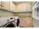 Functional laundry room with washer, dryer, and built-in storage at 7209 St Ledger Dr, Raleigh, NC 27613