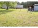 Large, grassy backyard with fenced area and a partial view of the house at 764 Olivers Grove Rd, Four Oaks, NC 27524