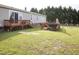 Spacious backyard featuring a wooden deck, partially fenced yard and mature trees at 764 Olivers Grove Rd, Four Oaks, NC 27524