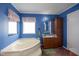 Bathroom featuring a soaking tub, wood vanity, and bright window at 764 Olivers Grove Rd, Four Oaks, NC 27524