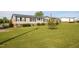 Single-story home with well manicured lawn and tidy landscaping and decorative items at 764 Olivers Grove Rd, Four Oaks, NC 27524