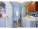 Functional laundry room with a washer, dryer, storage cabinets, and a door leading to other areas of the home at 764 Olivers Grove Rd, Four Oaks, NC 27524