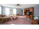 Cozy living room with plush seating, built-in shelving, a ceiling fan, and natural light from the windows at 764 Olivers Grove Rd, Four Oaks, NC 27524