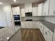 Kitchen featuring white cabinets, subway tiles, granite countertops, and stainless appliances at 798 Old Station Pointe, Angier, NC 27501
