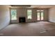 Spacious living room with a cozy fireplace, bright windows, and access to the backyard through French doors at 798 Old Station Pointe, Angier, NC 27501