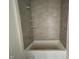 New bathroom shower with gray tile surround and built-in shelving, offering a sleek and modern design at 798 Old Station Pointe, Angier, NC 27501
