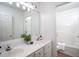 Bathroom featuring dual sinks, a large vanity, and a tub and shower combo behind a door at 8701 Erinsbrook Dr, Raleigh, NC 27617