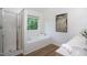 Bright bathroom with a soaking tub and a glass enclosed shower at 8701 Erinsbrook Dr, Raleigh, NC 27617