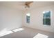 Bright bedroom featuring neutral carpet, ceiling fan, and double windows letting in natural light at 8701 Erinsbrook Dr, Raleigh, NC 27617