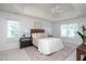 Bright bedroom with a tray ceiling, ceiling fan, and neutral-toned decor at 8701 Erinsbrook Dr, Raleigh, NC 27617