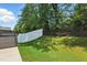 Backyard featuring a hot tub, a lawn, a black metal fence, and a white vinyl fence at 9120 Dupree Meadow Dr, Angier, NC 27501