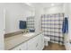 Bathroom featuring a vanity, a large mirror, and a shower-tub with a blue shower curtain at 9120 Dupree Meadow Dr, Angier, NC 27501