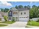 Beautifully landscaped two-story home with two-car garage, upper story balcony and manicured front lawn at 9120 Dupree Meadow Dr, Angier, NC 27501
