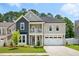 Charming two-story home features a welcoming front porch, two car garage, and beautifully landscaped yard at 9120 Dupree Meadow Dr, Angier, NC 27501