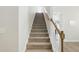 A carpeted staircase featuring wood handrails and white risers creating a welcoming and stylish transition between floors at 9120 Dupree Meadow Dr, Angier, NC 27501