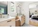 Bathroom with double vanity, terrazzo flooring, and view of bedroom at 939 Clarion Dr, Durham, NC 27705
