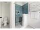 Modern bathroom with blue tile shower, glass door, and terrazzo floors at 939 Clarion Dr, Durham, NC 27705