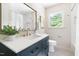 Bathroom featuring sleek fixtures, subway tile in the shower and a blue vanity cabinet at 939 Clarion Dr, Durham, NC 27705