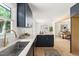 Bright kitchen showcasing stainless sink, tile backsplash, and modern dark blue cabinets at 939 Clarion Dr, Durham, NC 27705