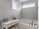 Bright bathroom featuring a soaking tub, vanity with drawers, and a large window at 100 Arrowtown Way, Kenly, NC 27542